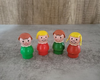 Peut inclure: Quatre figurines en plastique avec des visages et des cheveux peints. Les figurines portent des chemises de couleurs différentes et ont des couleurs de cheveux différentes. Les figurines sont toutes debout sur une surface grise.