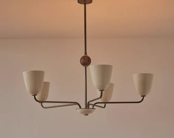 May include: A mid-century modern chandelier with five off-white, tulip-shaped shades. The fixture has a dark brown metal frame and a wooden accent. The light hangs from a ceiling mount.