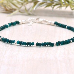 以下が含まれることがあります： シルバーのビーズと留め具が付いた、繊細な緑色の宝石のブレスレットです。