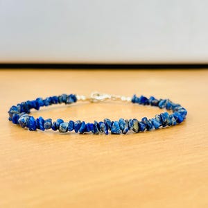 Könnte beinhalten: Ein Armband aus blauen Edelstein-Chips mit einem silbernen Verschluss.