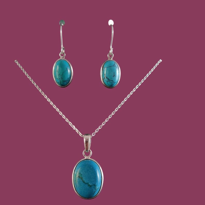 May include: A turquoise stone necklace and earrings set with silver chain and oval shaped stones.