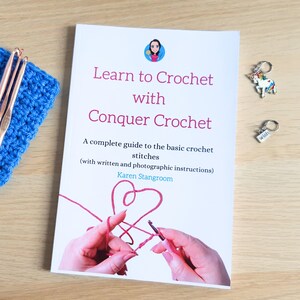 Peut inclure: Un livre intitul&eacute; "Learn to Crochet with Conquer Crochet" avec un c&oelig;ur rouge et un crochet sur la couverture. Le livre est un guide complet des points de crochet de base avec des instructions &eacute;crites et photographiques par Karen Stangroom.