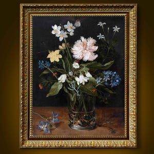 May include: A framed floral still life painting. The artwork features a bouquet of white, pink, yellow, and blue flowers in a clear glass vase with a silver base. The painting is set against a dark background and framed in a gold ornate frame.