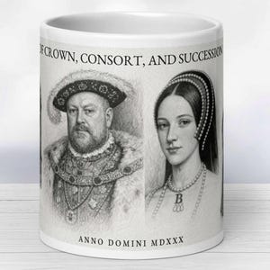 Könnte beinhalten: Weißer Keramikbecher mit Bleistiftporträts historischer Persönlichkeiten. Der Becher zeigt den Text "OF CROWN, CONSORT, AND SUCCESSION" und "ANNO DOMINI MDXXX". Die Porträts zeigen einen Mann in einem pelzbesetzten Gewand und eine Frau mit einer Perlenkette.