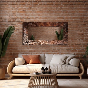 May include: A white couch with two pillows, a wooden coffee table, and a decorative mirror with a textured copper frame hanging on a brick wall.