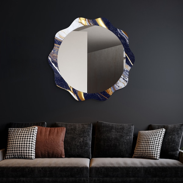 Könnte beinhalten: Ein runder Spiegel mit einem blauen und goldenen Marmorrahmen. Der Rahmen hat ein wellenförmiges Sonnenstrahlendesign. Der Spiegel hängt an einer dunkelgrauen Wand über einem schwarzen Sofa mit Kissen.