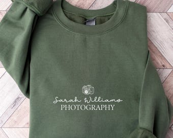May include: A green sweatshirt with a white camera icon and the text "Sarah Williams PHOTOGRAPHY" printed on the front.