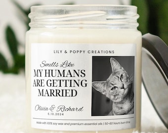 Puede incluir: Una vela blanca con una etiqueta negra que dice "Smells Like My Humans Are Getting Married" con una foto de un gato y el texto "Olivia & Richard 6.10.2024".
