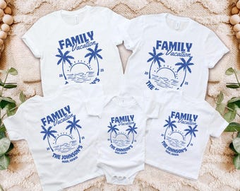May include: White t-shirts and a onesie with a blue graphic that reads "FAMILY Vacation" with palm trees, a sun, and the text "THE JOHNSON'S MAUI, HAWAII". The shirts are for a family vacation.