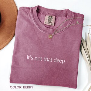 May include: A maroon coloured t-shirt with the text "it's not that deep" printed in white. The shirt is made of a soft, comfortable material.  COLOR: BERRY