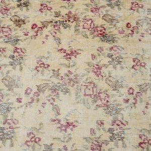 May include: A vintage rug with a cream background and a floral pattern in shades of pink, green, and brown.