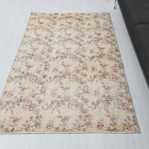 May include: A vintage floral patterned rug with a cream background and pink and red floral accents.