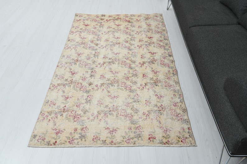 May include: A vintage floral patterned rug with a cream background and pink and red floral accents.