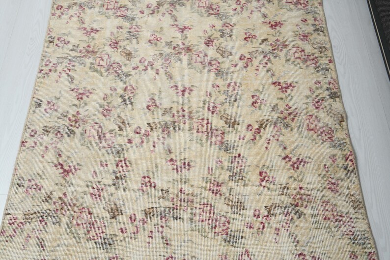 May include: A vintage floral patterned rug with a cream background and pink and green floral designs.