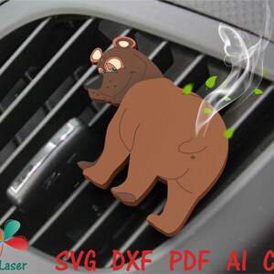 May include: A brown bear air freshener with a cartoon face and a cloud of smoke coming from its rear end. The bear is sitting in a car's air vent.