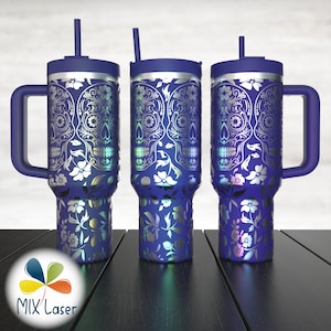 May include: Three blue insulated tumblers with silver sugar skull and floral designs. Each tumbler has a handle, a lid, and a straw. The tumblers are on a dark wooden surface.