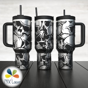 Op de afbeelding: Drie reistassen van roestvrij staal met zwarte deksels en handvatten. Elke tas heeft een schedelpatroon in zwart en wit.