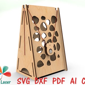 May include: A wooden toy with a triangular base and a patterned front. The toy has a string with a small bear-shaped object attached to it. The toy is designed for children to play with.