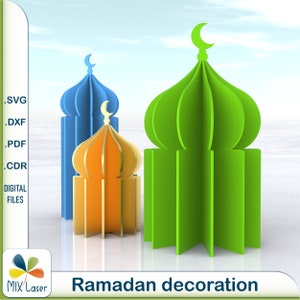Może przedstawiać: Trzy dekoracyjne struktury w kształcie meczetu w kolorze niebieskim, zielonym i pomarańczowym. Struktury są wykonane z papieru i przeznaczone do wycinania i składania. Obraz zawiera tekst "Ramadan decoration".