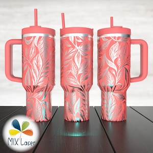 May include: Three pink stainless steel tumblers with a silver leaf pattern. Each tumbler has a lid and a straw. The tumbler on the left has a handle.