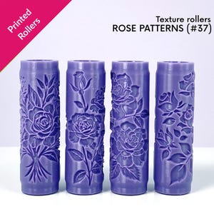May include: Four cylindrical texture rollers in a vibrant purple hue, each adorned with detailed rose patterns. The rollers are labeled "ROSE PATTERNS (#37)" and are designed for creating embossed designs. The words "Printed Rollers" are also visible.