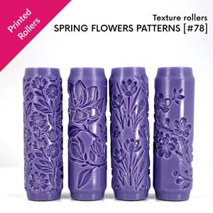 Puede incluir: Cuatro rodillos de textura cilíndricos de color morado con patrones de flores de primavera en relieve. El texto en la parte superior dice Printed Rollers, texture rollers y SPRING FLOWERS PATTERNS [#78]. Cada rodillo muestra un diseño floral.