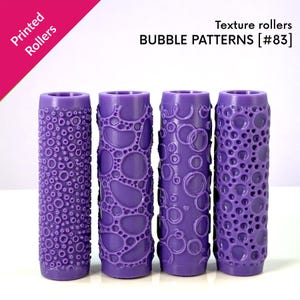Puede incluir: Cuatro rodillos de textura cilíndricos de color morado con distintos patrones de burbujas. El texto Printed Rollers y BUBBLE PATTERNS [#83] es visible en la parte superior. Cada rodillo tiene un diseño en relieve único de formas circulares.