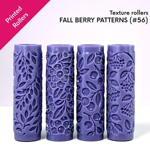 Może przedstawiać: Cztery fioletowe wałki do tekstury z jesiennymi wzorami jagód. Każdy wałek ma inny wytłoczony wzór jagód i liści. Widoczny jest tekst "Printed Rollers" i "FALL BERRY PATTERNS (#56)".