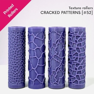 May include: Four cylindrical texture rollers in shades of purple, each with a different cracked pattern design. The text "Printed Rollers" is in the upper left corner, and "CRACKED PATTERNS [#52]" is displayed above the rollers.