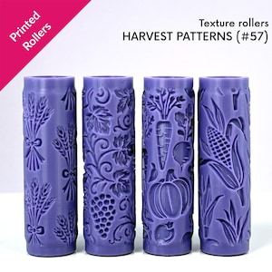 Peut inclure: Quatre rouleaux de texture violets avec des motifs de récolte. Chaque rouleau présente un motif différent : blé, raisins, carottes et citrouille, et maïs. Le texte "Printed Rollers" et "HARVEST PATTERNS (#57)" sont visibles.