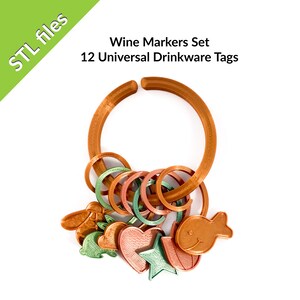 Op de afbeelding: Een set van 12 wijnbekermarkers in verschillende kleuren en vormen, waaronder een vis, een hart, een ster en een konijn. De markers zijn gemaakt van 3D-geprint plastic en zijn ontworpen om rond de steel van een wijnbeker te passen. De markers zijn bevestigd aan een grotere ring, ook gemaakt van 3D-geprint plastic.