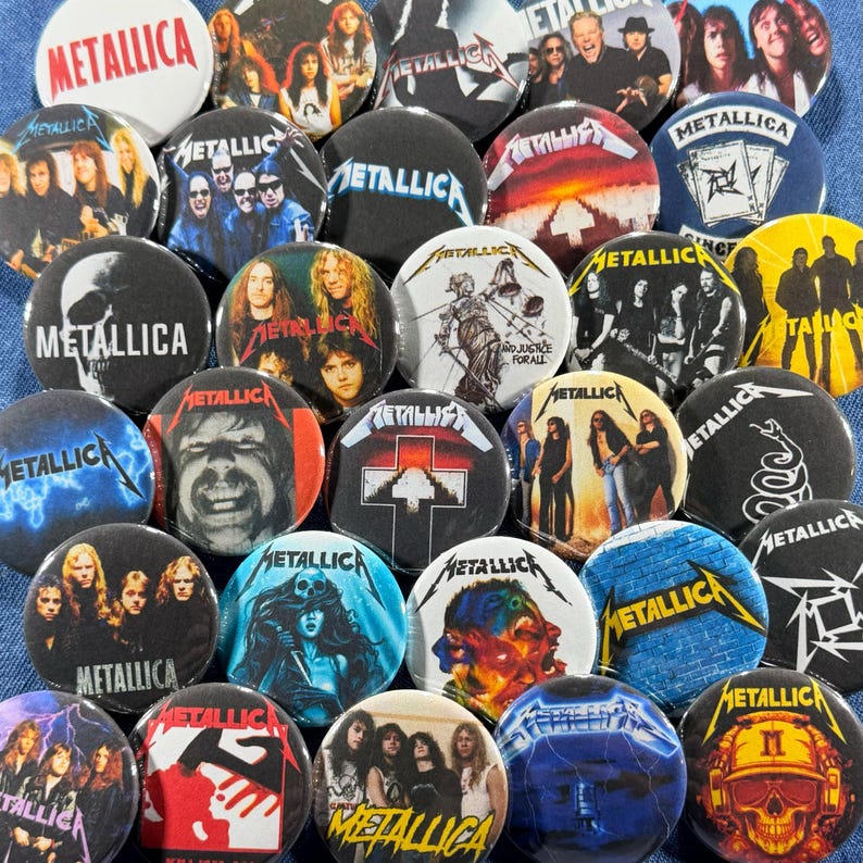 K&ouml;nnte beinhalten: Eine Sammlung runder Metall-Ansteckbuttons mit der Band Metallica. Die Buttons zeigen verschiedene Bilder, darunter Bandmitglieder, Albumcover und das Logo der Band. Die Buttons sind in verschiedenen Farben erh&auml;ltlich, darunter Schwarz, Wei&szlig;, Rot und Blau.