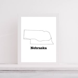 May include: A black and white line drawing of the state of Nebraska with the word "Nebraska" printed below the outline.