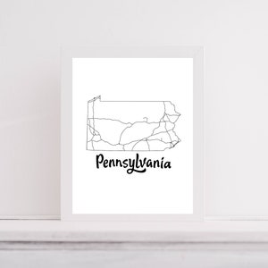 May include: A black and white line art print of the state of Pennsylvania with the word "Pennsylvania" written in cursive below the state outline.