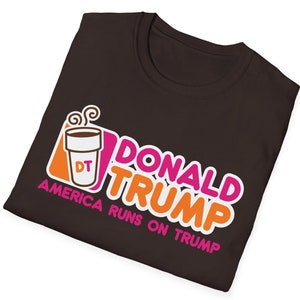 May include: A brown t-shirt with a parody of the Dunkin' Donuts logo. The logo says "Donald Trump" and "America Runs on Trump" with a coffee cup that says "DT" in the corner.