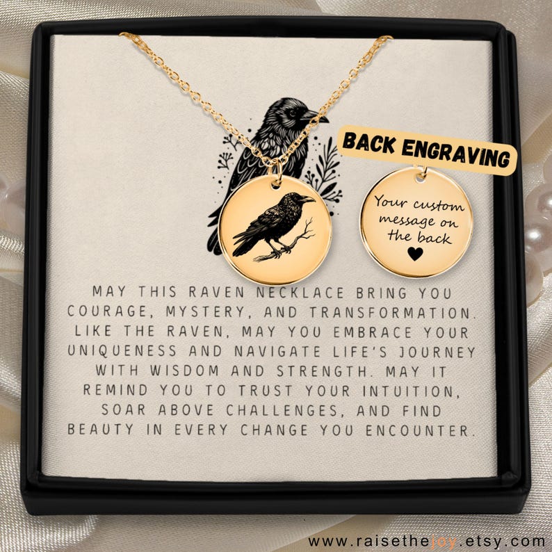 May include: A gold-toned circular pendant necklace featuring an engraved raven on a branch. The display card includes the text: MAY THIS RAVEN NECKLACE BRING YOU COURAGE, MYSTERY, AND TRANSFORMATION. A separate circular disc shows BACK ENGRAVING.