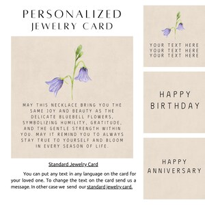 May include: A square beige jewelry card featuring a watercolor illustration of two purple bluebell flowers with green stems. The card includes printed text about the flowers and the phrase 'MAY THIS NECKLACE BRING YOU THE SAME JOY'.