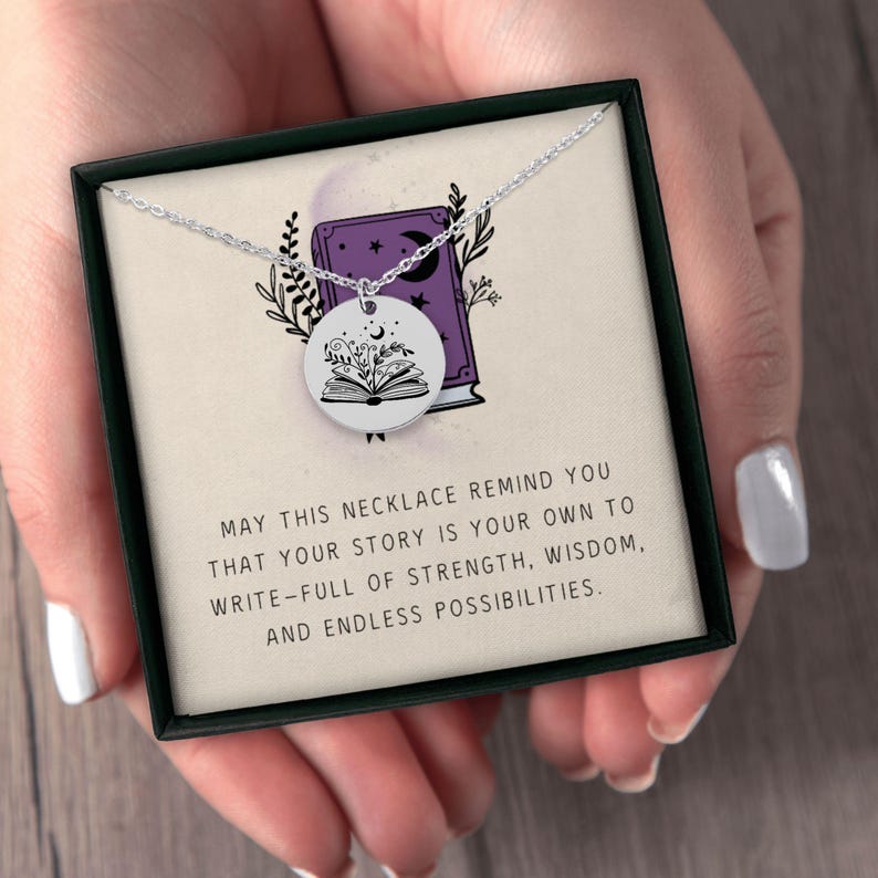 Pu&ograve; includere: Una collana d'argento con un ciondolo rotondo raffigurante un libro aperto con motivi floreali e celesti. La collana &egrave; presentata in una scatola nera con il testo: "MAY THIS NECKLACE REMIND YOU THAT YOUR STORY IS YOUR OWN TO WRITE-FULL OF STRENGTH, WISDOM, AND ENDLESS POSSIBILITIES."
