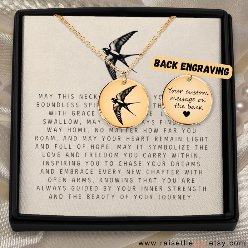 May include: Gold necklace with a round pendant featuring a black and white swallow design. The pendant has a message on the back that reads "Your custom message on the back". The necklace is in a white box with a message about the swallow symbolizing freedom and hope.