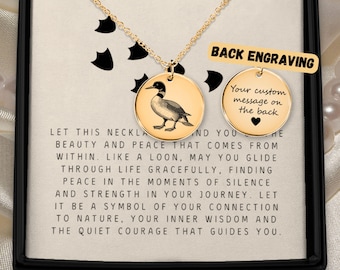 Könnte beinhalten: Goldfarbene Halskette mit rundem Anhänger, der eine Abbildung eines Eistauchers zeigt. Die Halskette wird in einer schwarzen Schachtel präsentiert, mit dem Text "BACK ENGRAVING" und "Your custom message on the back". Der Text enthält auch eine Botschaft über Frieden und Natur.