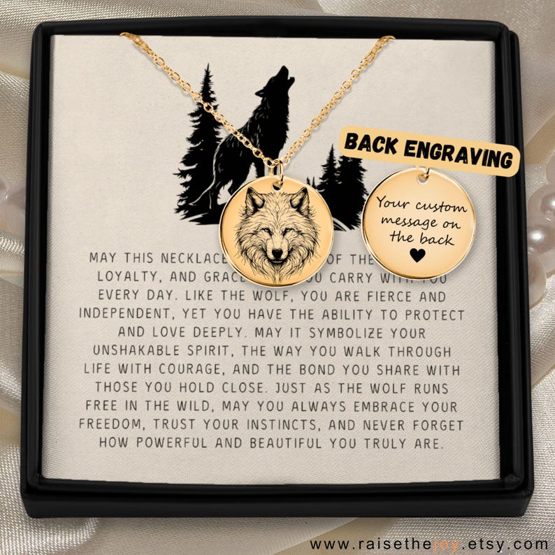 K&ouml;nnte beinhalten: Eine goldfarbene Halskette mit einem Wolf-Anh&auml;nger, pr&auml;sentiert in einer schwarzen Box. Der Anh&auml;nger zeigt ein detailliertes Wolfsportr&auml;t. Der Text "Back Engraving" ist sichtbar, zusammen mit einer Botschaft &uuml;ber Loyalit&auml;t und Mut.