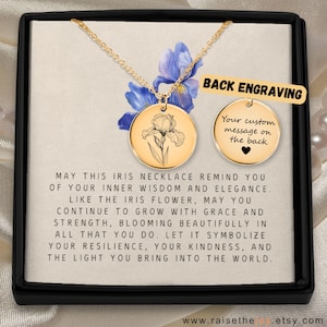 Puede incluir: Collar con colgante de flor de iris dorado, presentado en una caja negra. El colgante tiene un diseño de flor de iris grabado. El texto en la caja dice: "MAY THIS IRIS NECKLACE REMIND YOU..." y "BACK ENGRAVING."