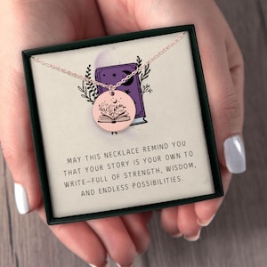 Pu&ograve; includere: Una collana in oro rosa con un ciondolo rotondo raffigurante un libro aperto con dettagli floreali. La collana &egrave; presentata in una confezione regalo nera con la scritta: "MAY THIS NECKLACE REMIND YOU..."
