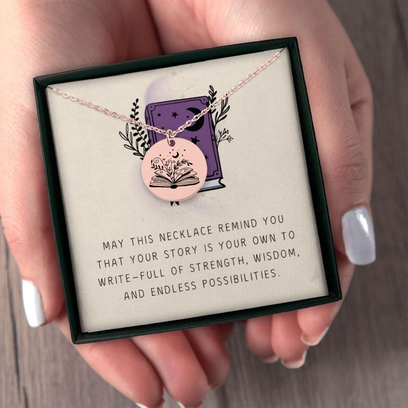 Pu&ograve; includere: Una collana in oro rosa con un ciondolo rotondo raffigurante un libro aperto con dettagli floreali. La collana &egrave; presentata in una confezione regalo nera con la scritta: "MAY THIS NECKLACE REMIND YOU..."