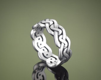 May include: A silver Celtic knot ring with a braided design.