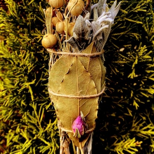 May include: A dried herb bundle wrapped in bay leaves and tied with twine. The bundle includes dried sage, dried berries, and a dried rose bud.