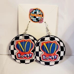 May include: A pair of round earrings with a black and white checkered pattern. Each earring features the words "NO DOUBT" in a red, blue, and yellow design. The earrings have silver-colored hooks and are displayed on a white card with a logo.