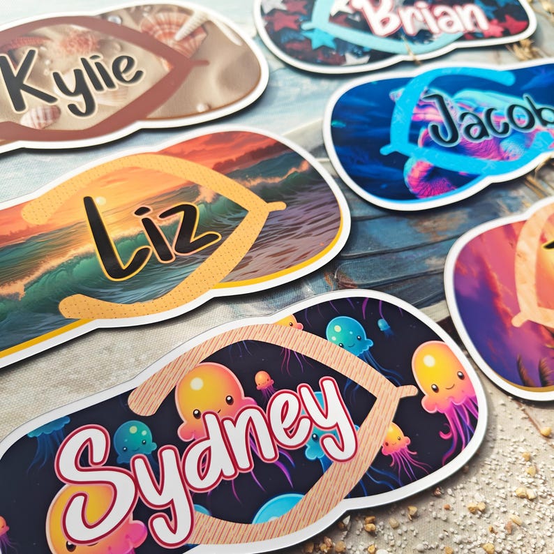 May include: A selection of personalised flip-flop-shaped stickers. Each sticker displays a name in a stylish font, with diverse beach-themed backgrounds, including seashells, ocean waves, and jellyfish. The stickers are in shades of brown, blue, orange, and pink.