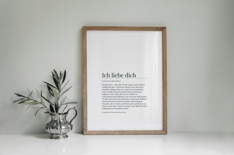 May include: A framed print with a white background and black text. The text reads "Ich liebe dich" which is German for "I love you". The text is a definition of the word "love" in German.