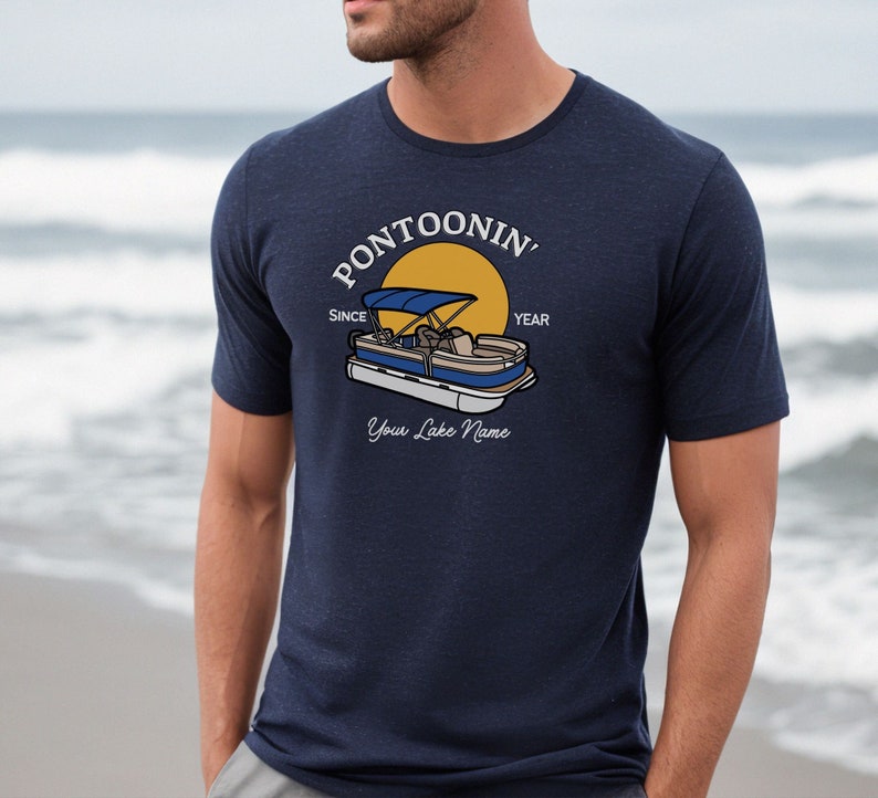 K&ouml;nnte beinhalten: Ein marineblaues T-Shirt mit einer wei&szlig;en Grafik eines Pontonboots auf einem See mit einer gelben Sonne und dem Text "Pontoonin' Since Year Your Lake Name".